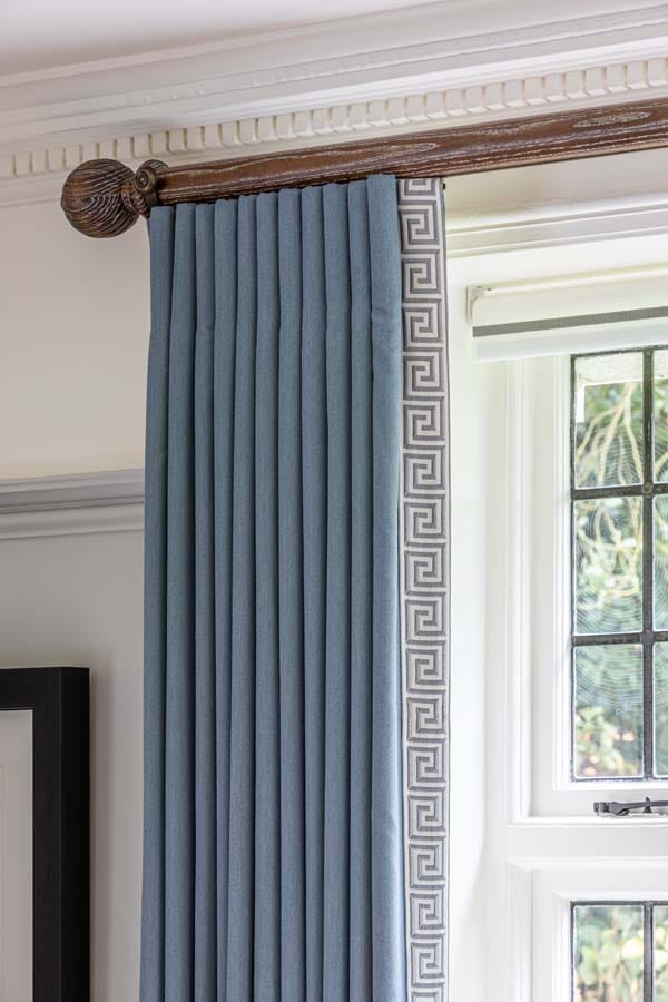 Blue wool full length curtains with Greek Key trim down leading edge on bespoke wooden pole.