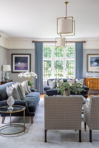 Formal drawing room in greys and blue with bespoke upholstery and cushions.